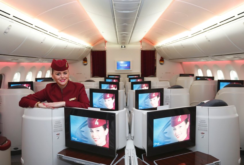 A flight attendant poses poses for a photograph in the business class cabin of the new Boeing 787 Dreamliner after it arrived on it's inaugural flight to Heathrow Airport, west London December 13, 2012. Qatar Airways is the first airline to operate scheduled Dreamliner flights to and from the UK. REUTERS/Andrew Winning (BRITAIN - Tags: TRANSPORT BUSINESS SOCIETY TRAVEL)